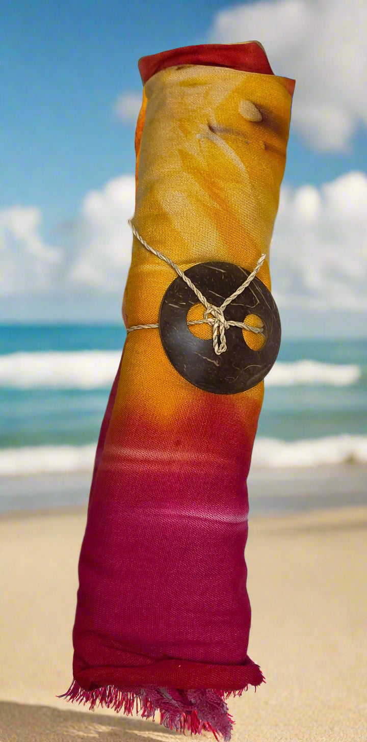 Colorful sarong yellow red pink with decorative coconut shell buckle on a marble surface