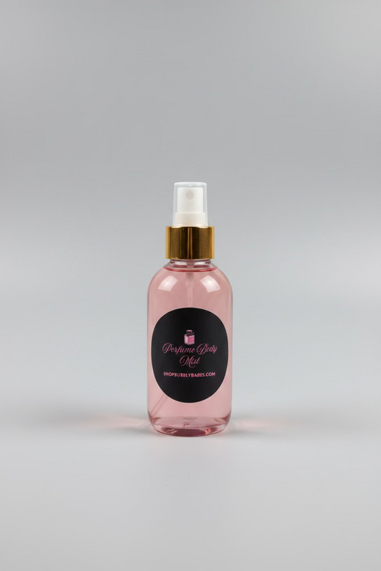 A bottle of perfume body mist with a gold spray nozzle and a black circular label reading 'Perfume Body Mist SHOPFUELTRAVEL.COM', placed on a light wooden table in a kitchen or storage room setting.